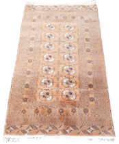 A Bokhara red ground rug, the central field decorated with fourteen repeating medallions, within flo