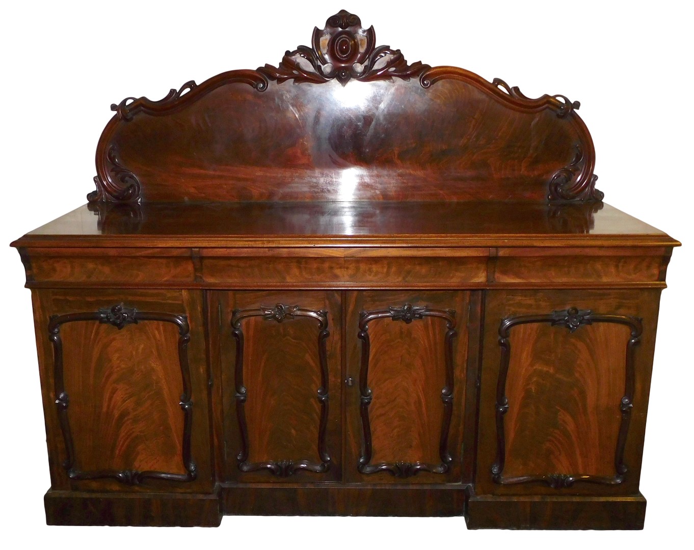 A Victorian mahogany break front sideboard, with a carved back over one long and two short cushion d