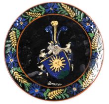 A Desa Steffisburg pottery dish, decorated with "Sommer" with a coat of arms, within a repeating flo