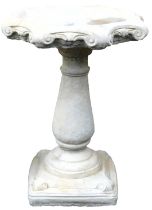 A concrete birdbath, of octagonal scrolling form, raised on a baluster column, on a square base, 66c