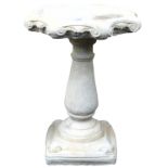 A concrete birdbath, of octagonal scrolling form, raised on a baluster column, on a square base, 66c