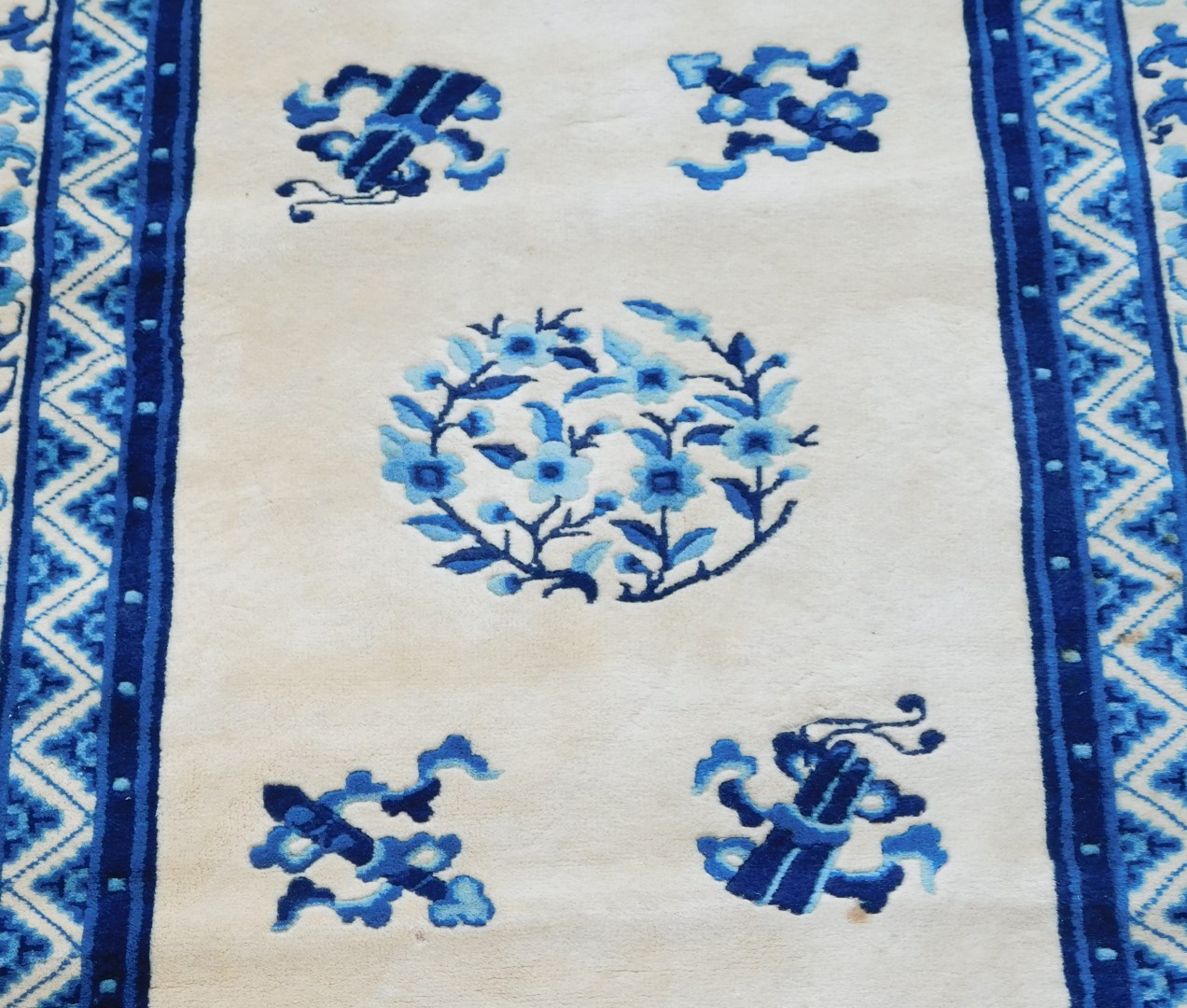 A Chinese blue and cream ground rug, decorated with flowers and buddhist emblems, within repeating f - Image 2 of 3