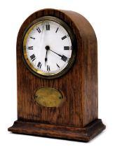 An early 20thC oak cased mantel clock, circular enamel dial bearing Roman numerals, Buren clockwork