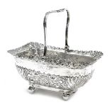 A Victorian silver sugar basket, with embossed and engraved foliate decoration, raised on four ball