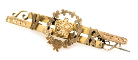 A Queen Victoria commemorative 9ct gold bar brooch, set centrally with a crown within a wreath, flan