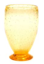 A Whitefriars amber glass vase, of footed form, with bubble inclusions, designed by W Wilson, circa
