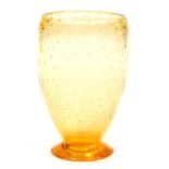 A Whitefriars amber glass vase, of footed form, with bubble inclusions, designed by W Wilson, circa