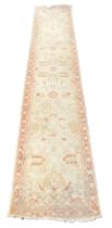 A Turkish cream ground runner, with floral decoration, within a repeating floral border, 384cm x 77c