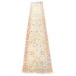 A Turkish cream ground runner, with floral decoration, within a repeating floral border, 384cm x 77c