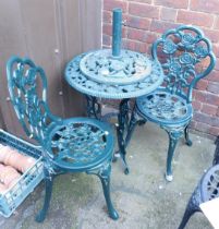 A green painted cast metal garden set, comprising table, two chairs and parasol stand.