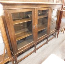 A 20thC oak display cabinet, the top with a raised back above three drawers enclosing shelves, with