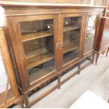 A 20thC oak display cabinet, the top with a raised back above three drawers enclosing shelves, with