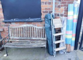 A teak garden bench, with cast metal ends, together with an A frame step ladder, gazebo wind breaker