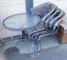 A garden dining set, comprising four wicker chairs, together with a glass topped table.