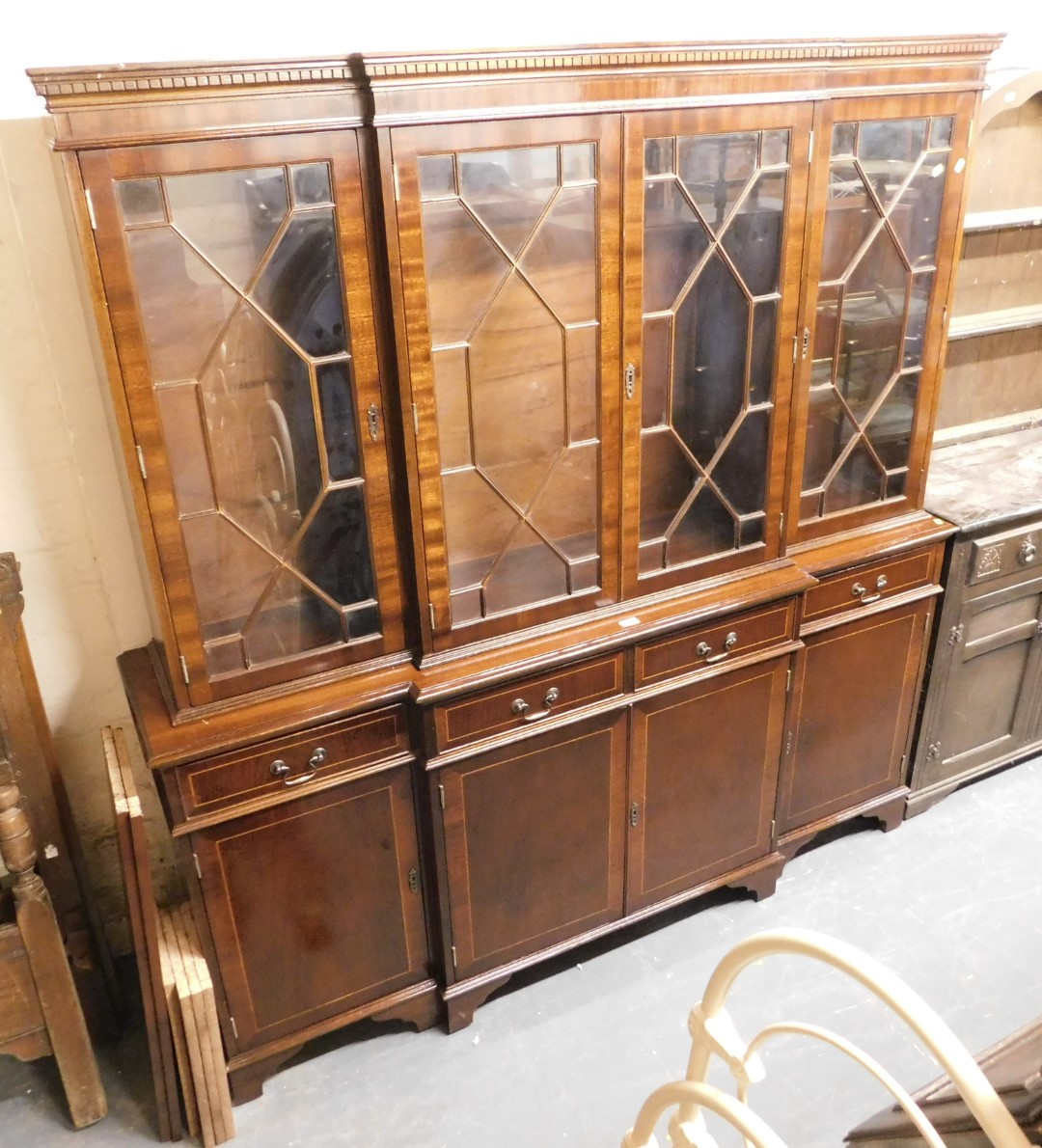 A 20thC Regency style mahogany breakfront display cabinet, the top with a moulded edge with dentil m