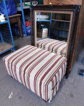 A wall mirror, together with a footstool, upholstered in striped fabric.