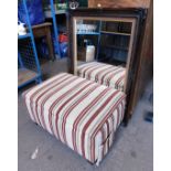 A wall mirror, together with a footstool, upholstered in striped fabric.