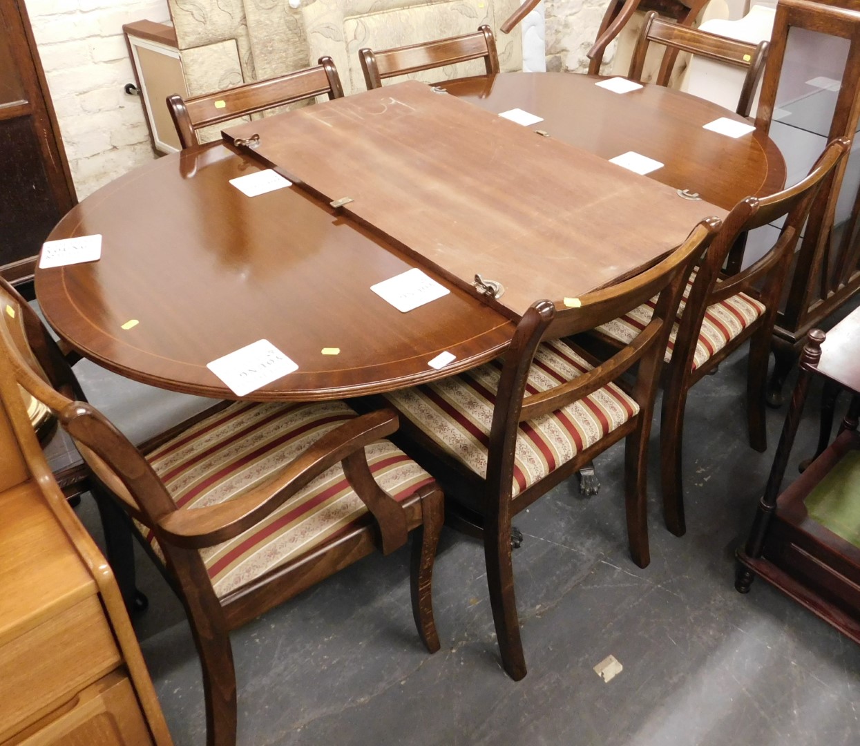 A 20thC mahogany and inlaid extending dining table, together with six Regency style chairs with drop