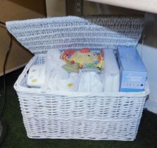 A white linen hamper, with lid, various baby's linen to interior.