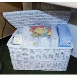 A white linen hamper, with lid, various baby's linen to interior.