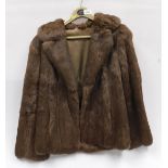 A lady's size 10 three quarter length fur coat.