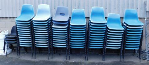 A large quantity of plastic stacking chairs.