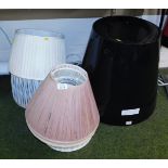 A group of pleated lamp shades, together with a black plastic shade of tapering form, 48cm high.