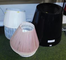 A group of pleated lamp shades, together with a black plastic shade of tapering form, 48cm high.