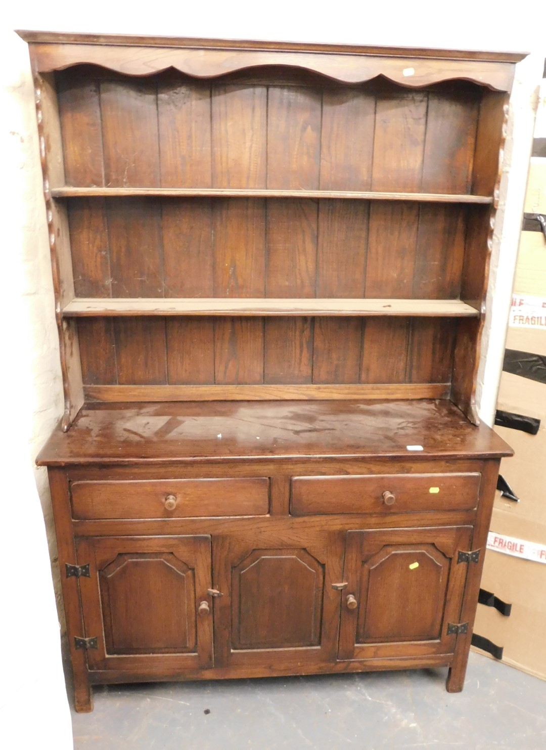 An oak stained dresser, with plate rack over base unit of two drawers over three panelled doors, rai