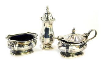 A silver three piece matched cruet set, comprising salt and lidded mustard, Birmingham 1964, with bl