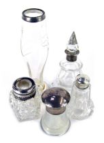 Five Edward VII and later silver topped cut glass bottles and jars, including a scent bottle and sto