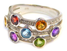 A 9ct white gold multi stone set dress ring, of three layered design, set with semi precious stones,