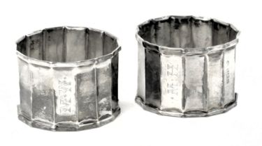 A matched pair of George V silver napkin rings, each of hammered rectangular form bearing the initia