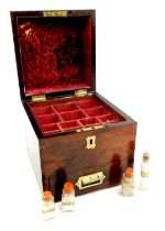 A Victorian rosewood medicine chest, the hinged lid with brass handle enclosing a red velvet lined i