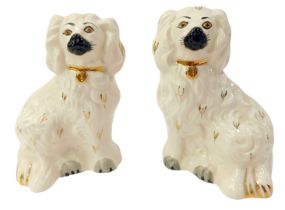 A pair of Royal Doulton pottery figures, modelled as spaniels, in cream with gilt highlights, printe