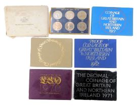 A group of coin packs, comprising 1977, 1976, 1982, 1971, 1970 (x2), and a Crowns of Great Britain p