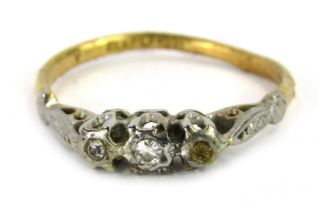 A Victorian three stone dress ring, set with three tiny diamonds, in a raised white metal setting, o