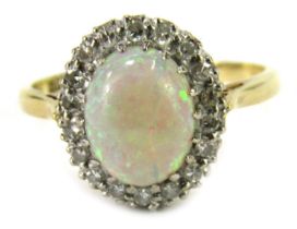 An Elizabeth II 18ct gold opal and diamond dress ring, the oval cabochon opal in claw setting surrou