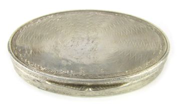 An oval white metal snuff box, with engine engraved design, and two lipped opening, white metal stam