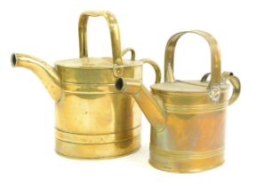 Two Victorian brass watering cans, each with strap handle, 28cm and 24cm high.