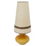 A mid century German amber glass table lamp, of compressed circular form, on brassed circular base w