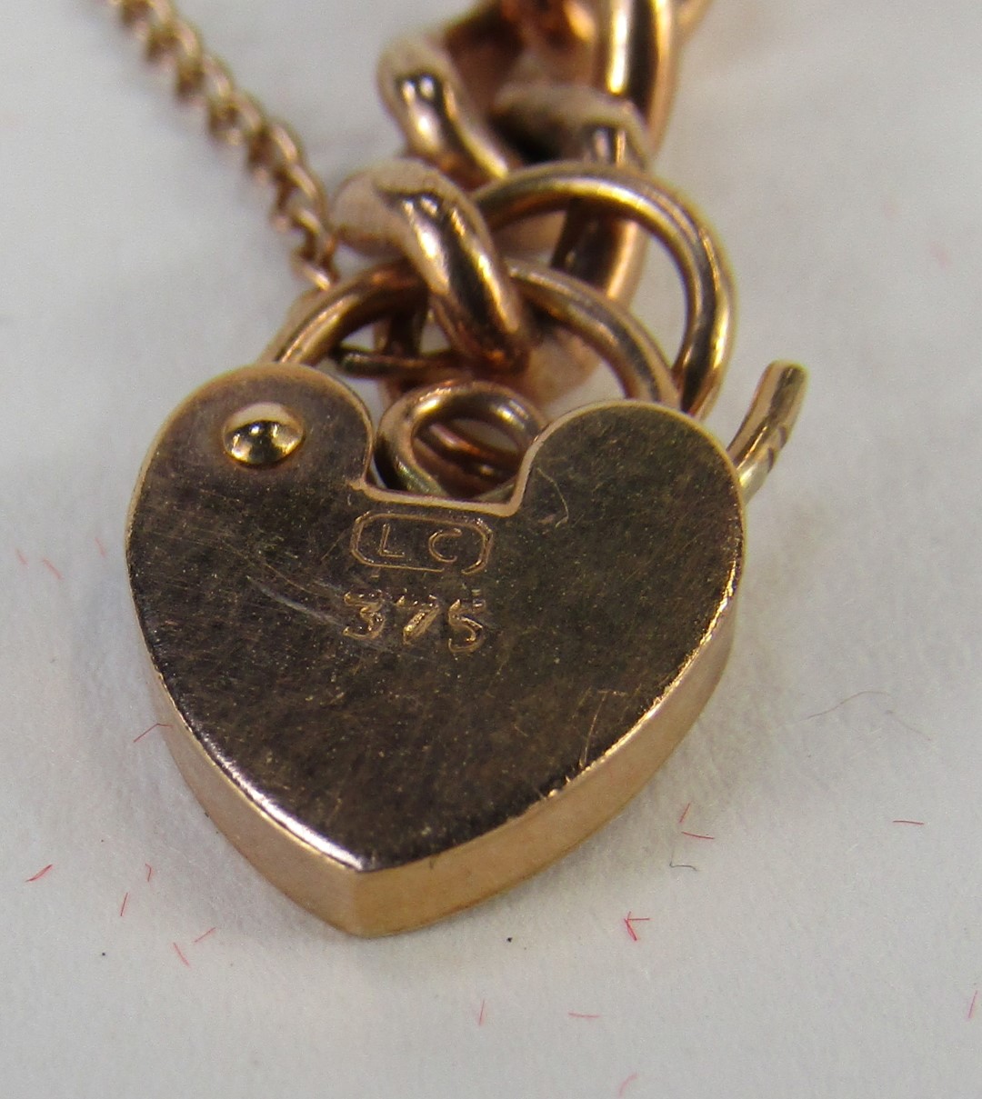 A rose gold curb link bracelet, with heart shaped padlock, clip and safety chain, yellow metal, stam - Image 2 of 2