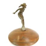 A 1920's car mascot, modelled as a nude lady, mounted on a circular hardwood base, 22cm high overall