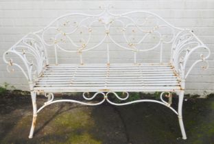 A 20thC wrought metal two seater garden bench, in white, with scroll motifs and slatted base, 142cm