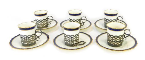 A set of six George V Aynsley porcelain coffee cans and saucers, each on a white ground with gilt fl