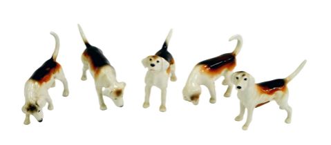 Five Beswick pottery hounds, in various poses, the largest 6.5cm high.