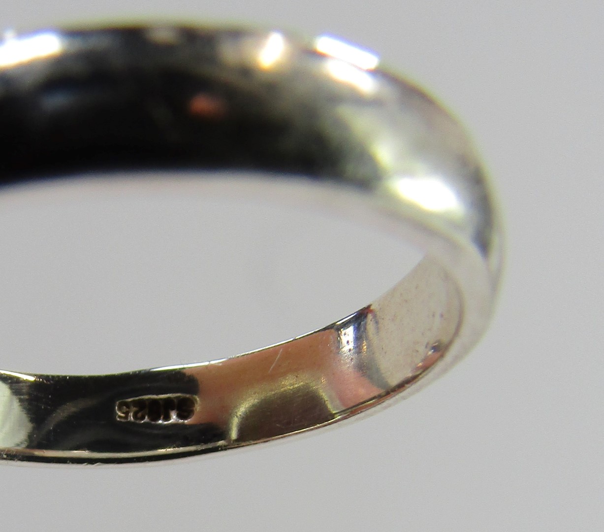 A dress ring, with a rectangular cut and faceted pale green stone, in a rub over white metal border - Image 3 of 3