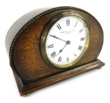 An early 20thC oak cased mantel clock, the circular white enamel dial bearing Roman numerals for Fra