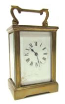 An early 20thC brass cased carriage clock, the square white enamel dial bearing Roman numerals, with