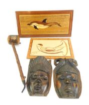A group of treen, to include two carved masks, two inlaid wooden wall plaques depicting a dolphin, a